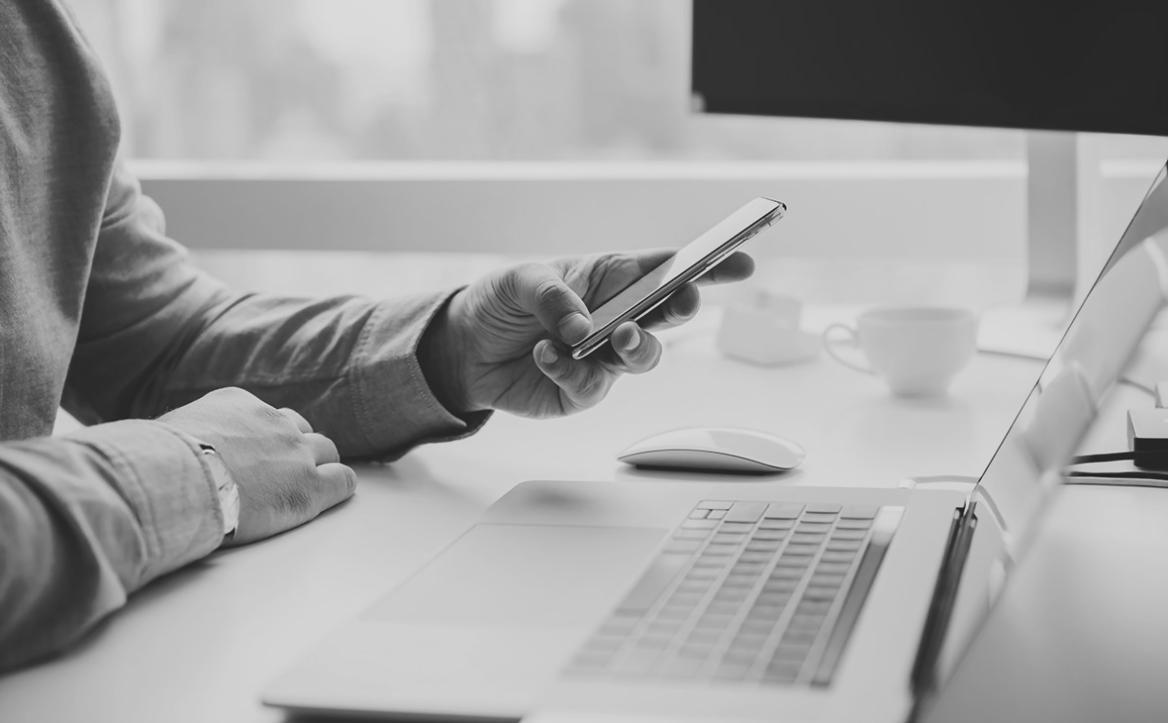 Designer working on logo sketches with grid system visible on screen